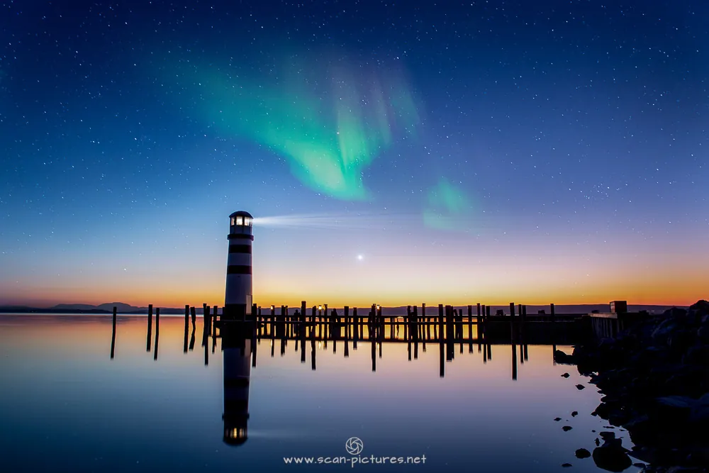Polarlicht über einem Leuchtturm und einem Steg