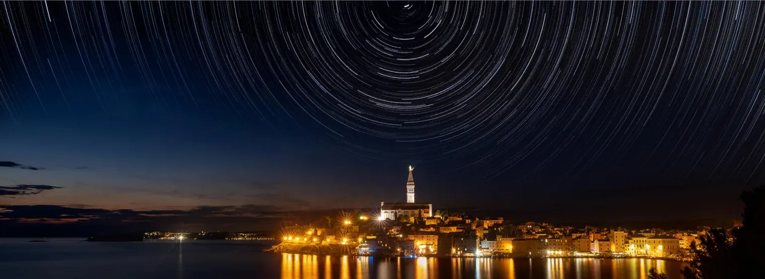 Sternspuren über der beleuchteten Altstadt von Rovinj am Meer
