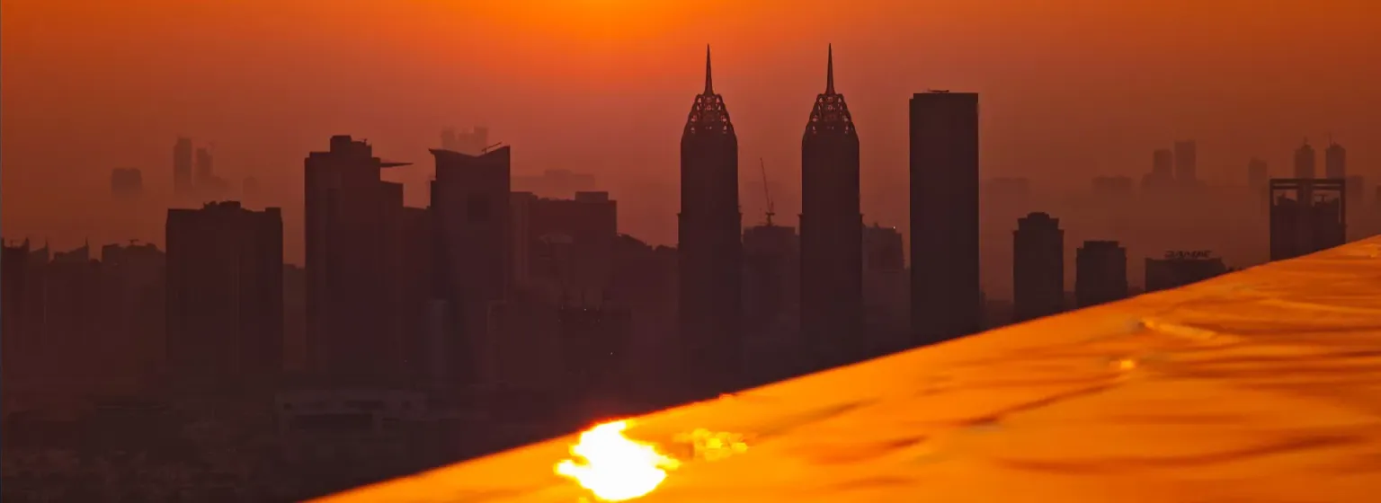 Sonnenaufgang über der Skyline von Dubai, gesehen über einen Infinity-Pool